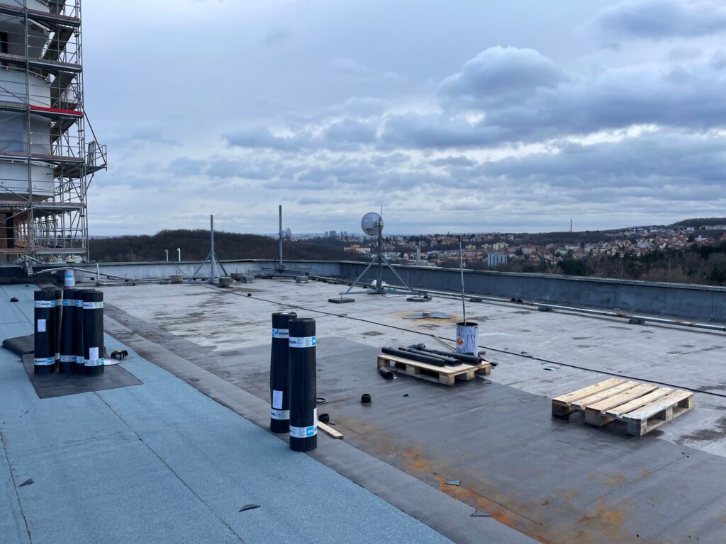 Postup pokládky asfaltových pásov na pôvodnú strechu – hydroizolácia plochých striech, Nemocnica Na Homolce, Praha